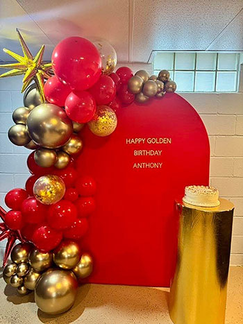 Corrales Designs red and gold Golden Birthday balloon display