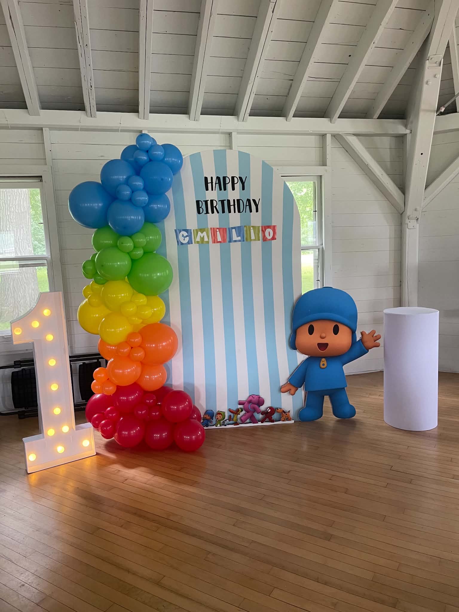 A Colorful Pocoyo Celebration With blue, green, yellow, orange, red balloons and a blue white and striped background